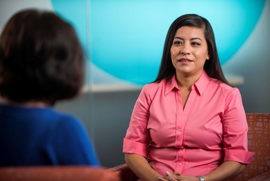 Two teachers chat as they face each other.